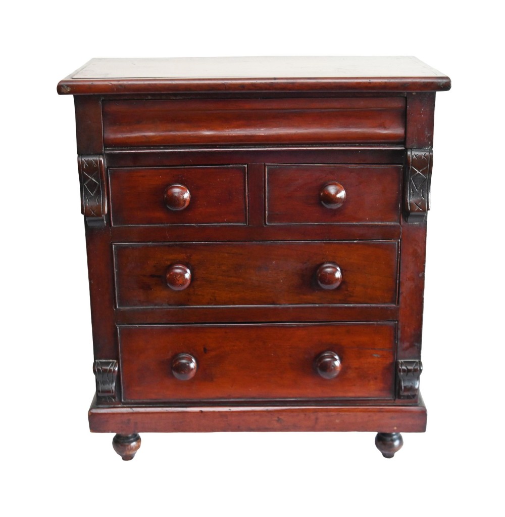 A 19th-century Scottish mahogany miniature apprentice chest featuring two short over two long drawers, a top cushion drawer, turned knobs, carved corbels, and turned feet. View III