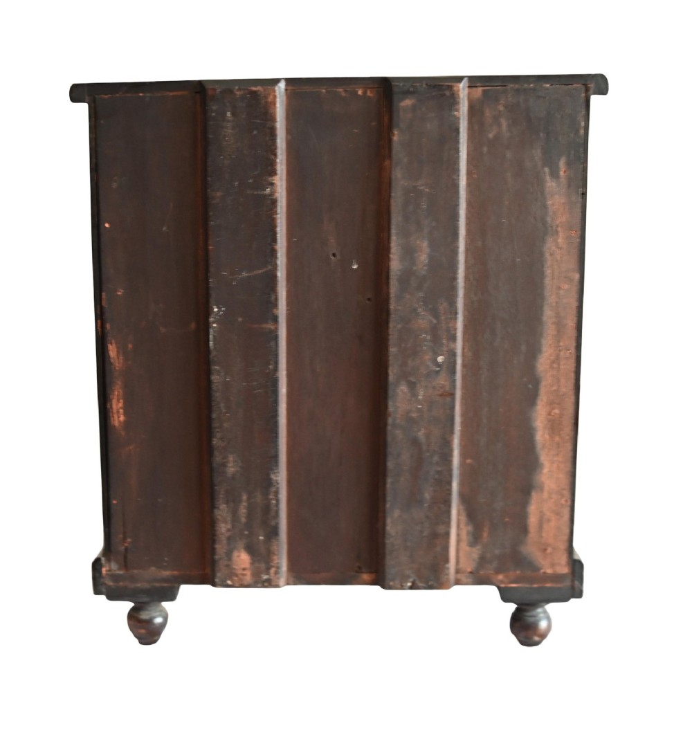 A 19th-century Scottish mahogany miniature apprentice chest featuring two short over two long drawers, a top cushion drawer, turned knobs, carved corbels, and turned feet. View VII