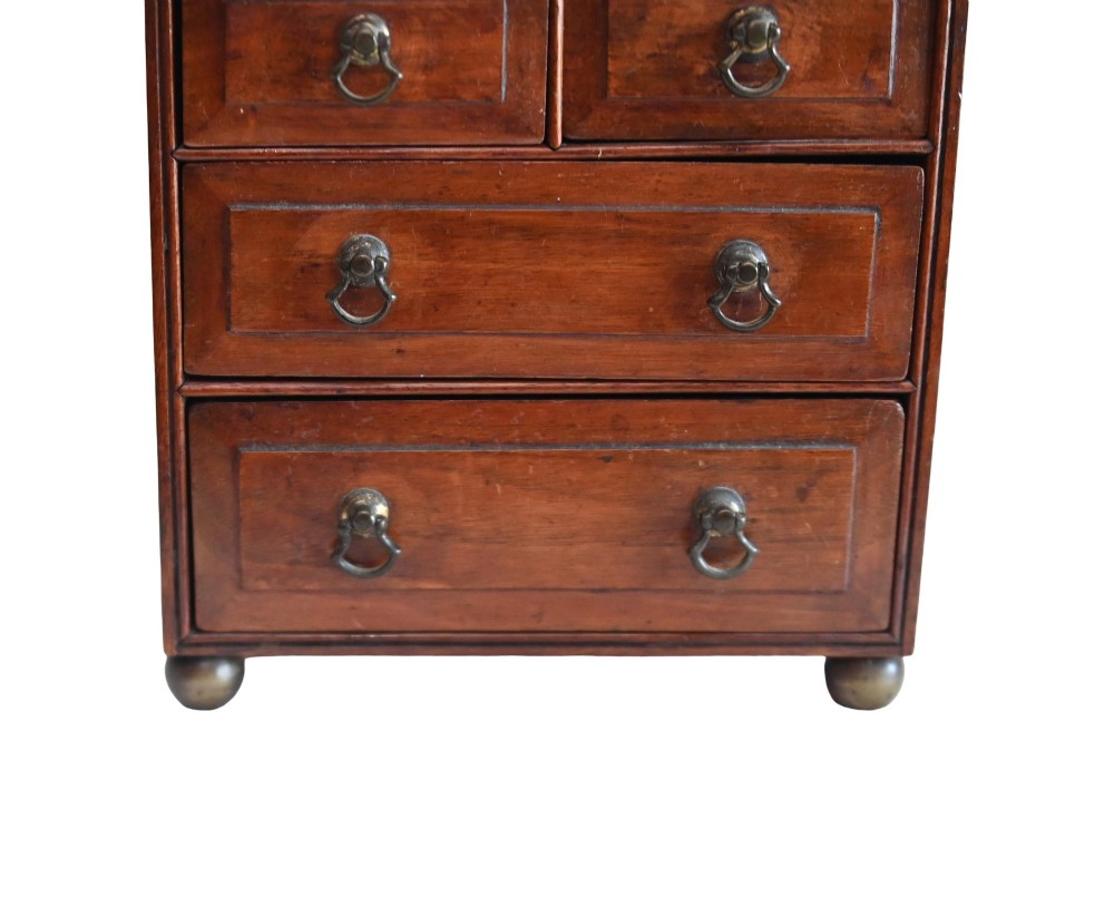 A Georgian Revival mahogany apprentice chest featuring two small top drawers over two full-width drawers with brass drop handles and an inlaid top border. View II
