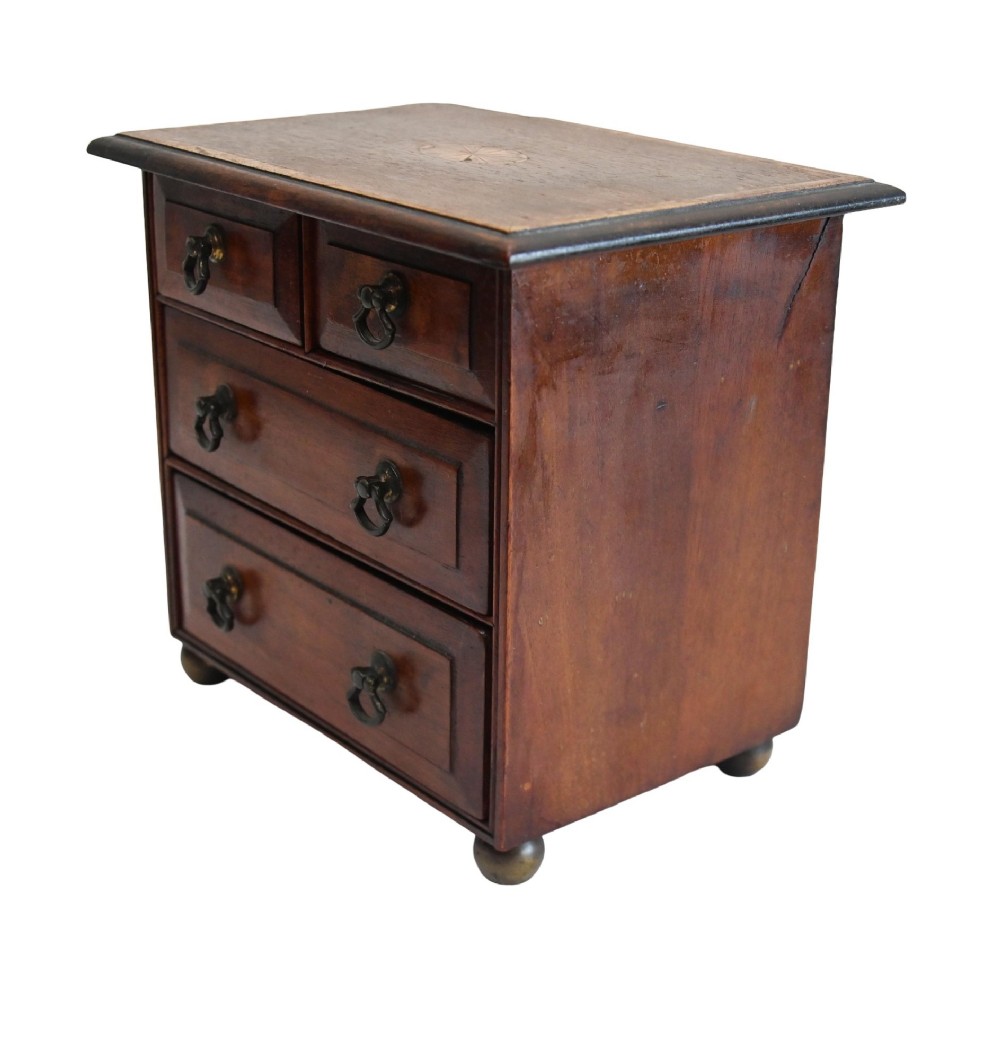 A Georgian Revival mahogany apprentice chest featuring two small top drawers over two full-width drawers with brass drop handles and an inlaid top border. View V