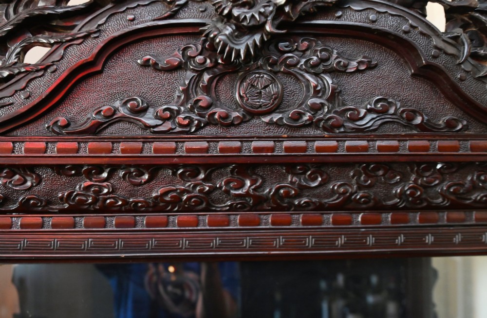 An intricately carved dark hardwood Japanese Meiji display cabinet featuring a dragon pediment, glazed door, and tiered asymmetrical shelves. View VI
