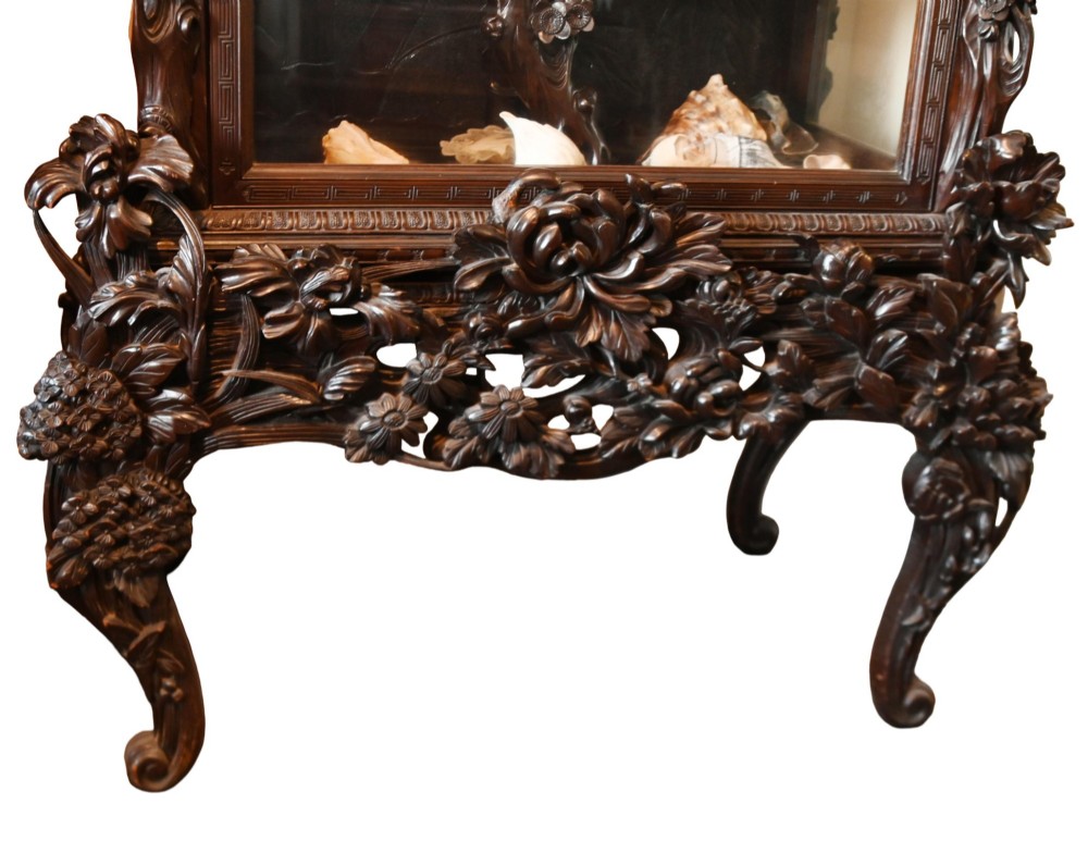 An intricately carved dark hardwood Japanese Meiji display cabinet featuring a dragon pediment, glazed door, and tiered asymmetrical shelves. View VII