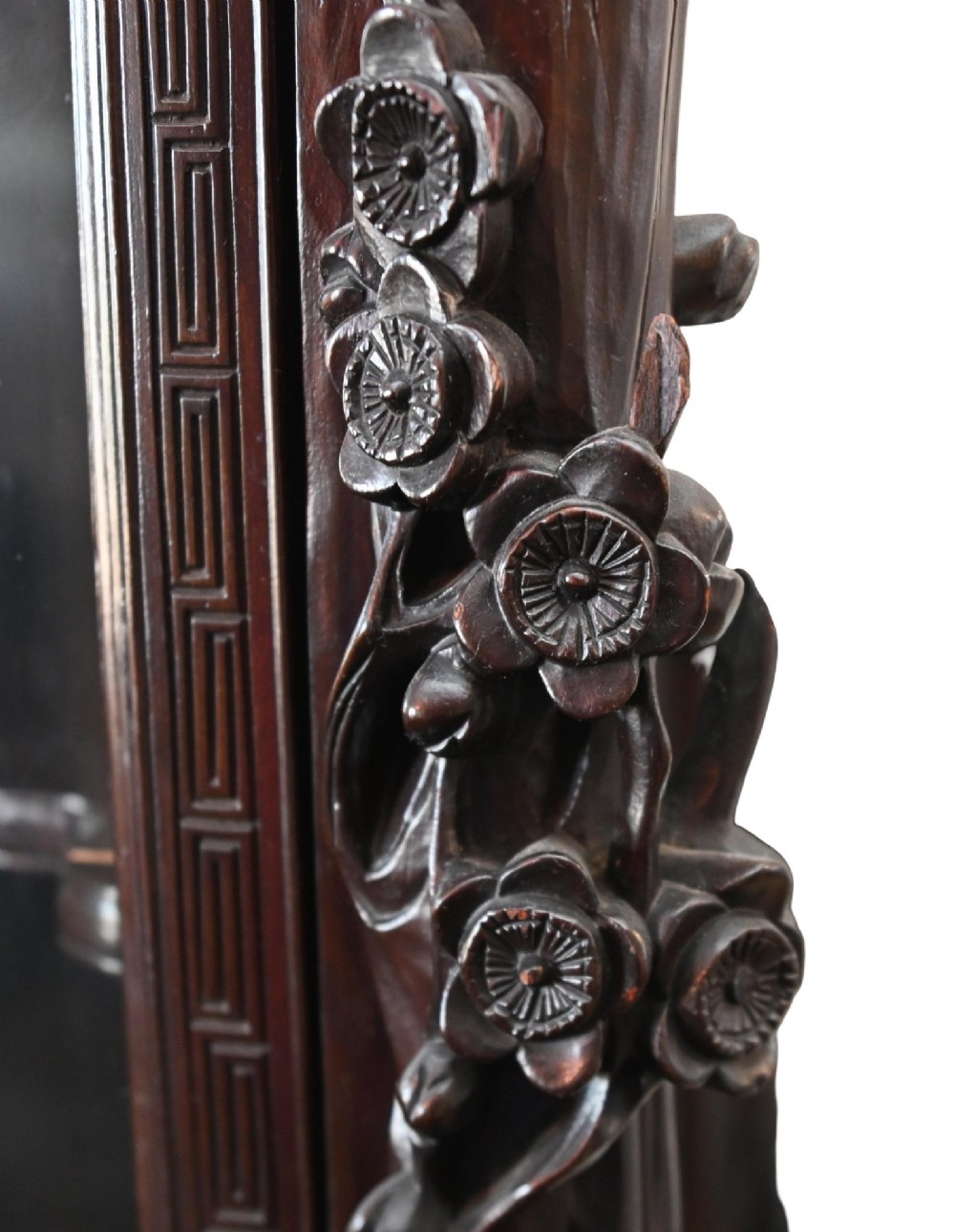 An intricately carved dark hardwood Japanese Meiji display cabinet featuring a dragon pediment, glazed door, and tiered asymmetrical shelves. View X