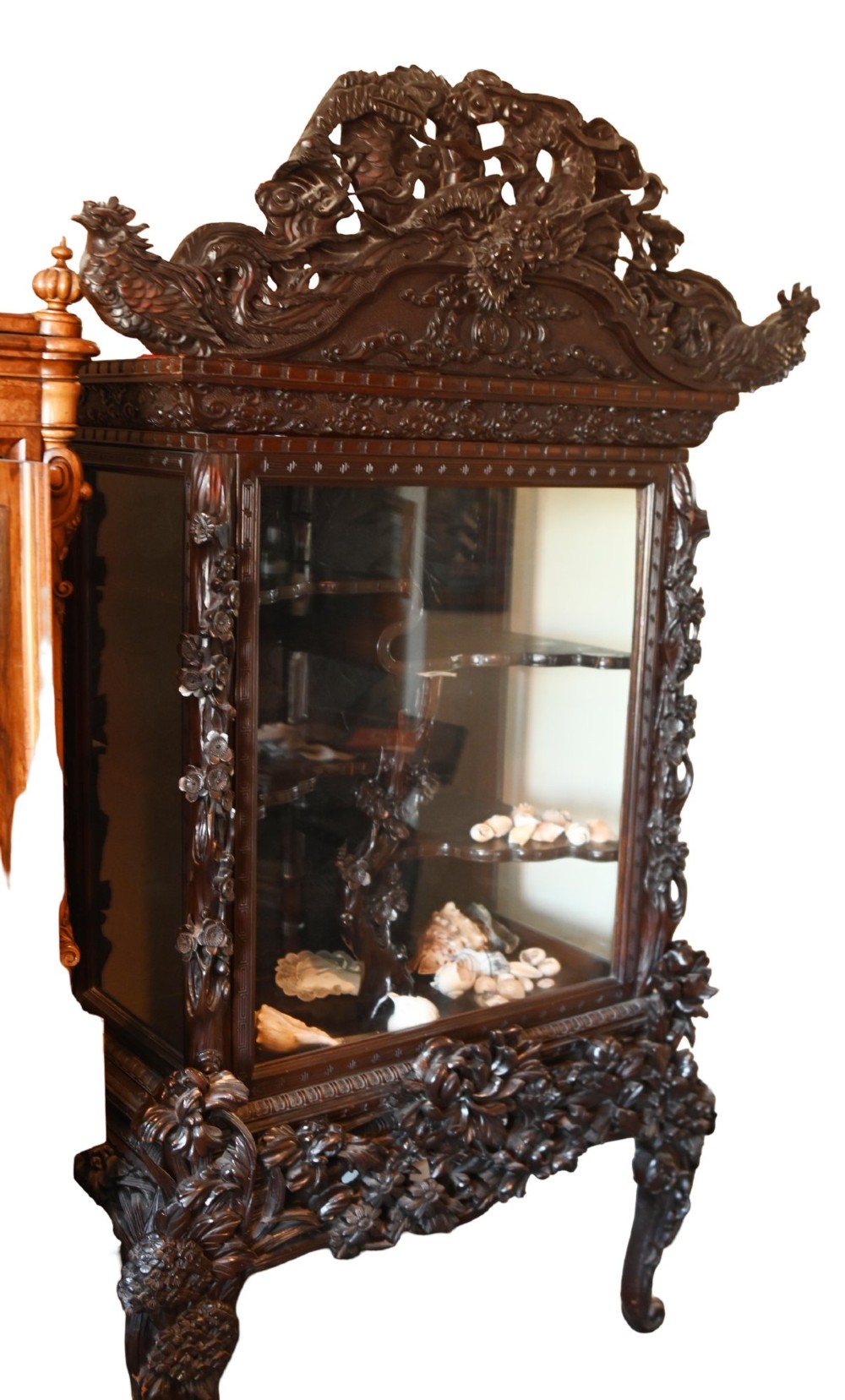 An intricately carved dark hardwood Japanese Meiji display cabinet featuring a dragon pediment, glazed door, and tiered asymmetrical shelves. View XII