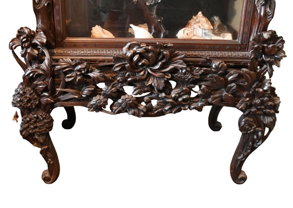An intricately carved dark hardwood Japanese Meiji display cabinet featuring a dragon pediment, glazed door, and tiered asymmetrical shelves. View XIII