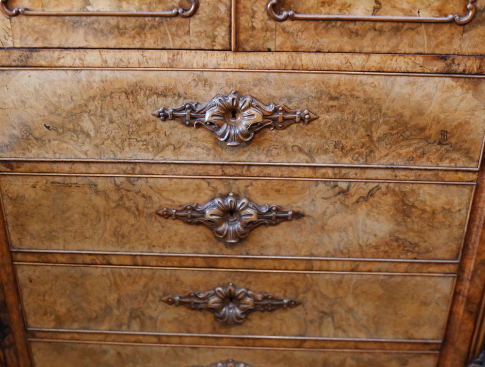 A tall 19th-century French Louis Philippe secretaire desk featuring figured birds-eye maple veneer, carved wooden handles, upper cabinet doors, and finials on top. View III