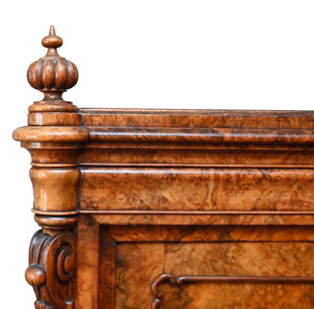 A tall 19th-century French Louis Philippe secretaire desk featuring figured birds-eye maple veneer, carved wooden handles, upper cabinet doors, and finials on top. View IV