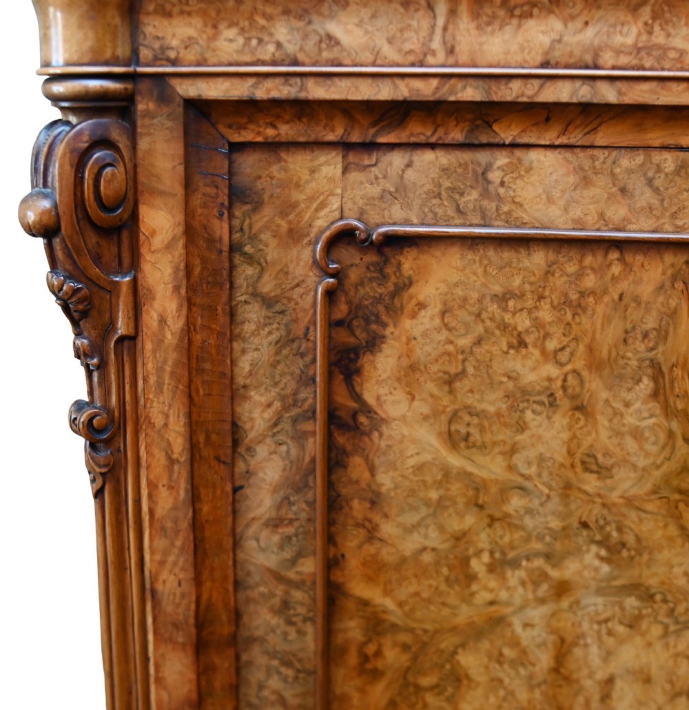 A tall 19th-century French Louis Philippe secretaire desk featuring figured birds-eye maple veneer, carved wooden handles, upper cabinet doors, and finials on top. View V