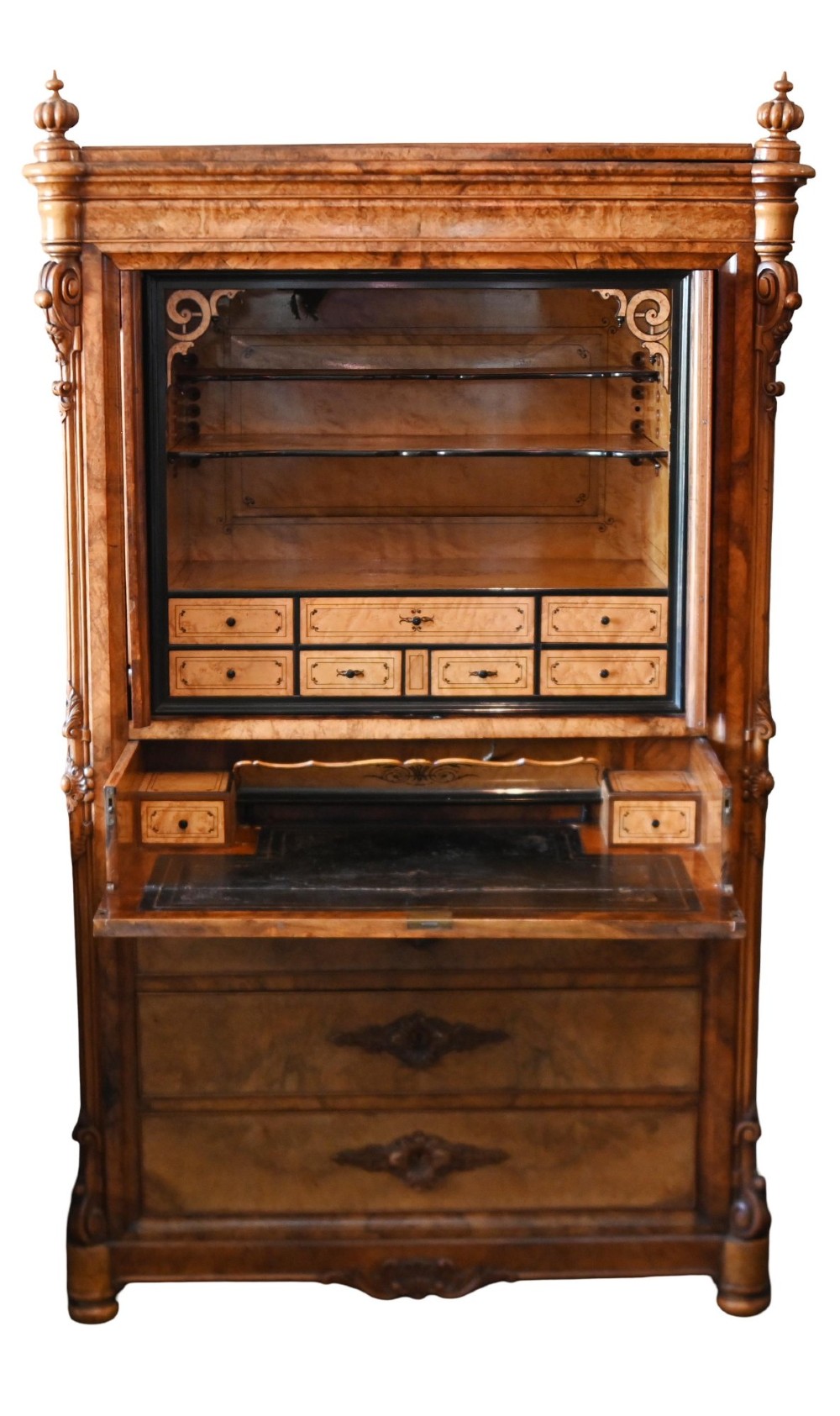A tall 19th-century French Louis Philippe secretaire desk featuring figured birds-eye maple veneer, carved wooden handles, upper cabinet doors, and finials on top. View VIII
