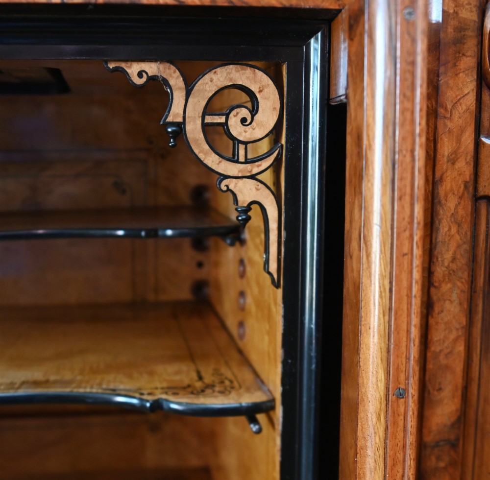 A tall 19th-century French Louis Philippe secretaire desk featuring figured birds-eye maple veneer, carved wooden handles, upper cabinet doors, and finials on top. View IX