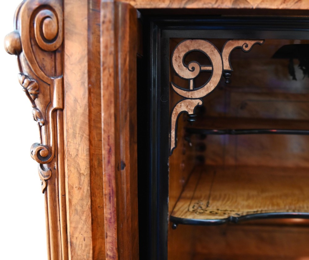 A tall 19th-century French Louis Philippe secretaire desk featuring figured birds-eye maple veneer, carved wooden handles, upper cabinet doors, and finials on top. View X