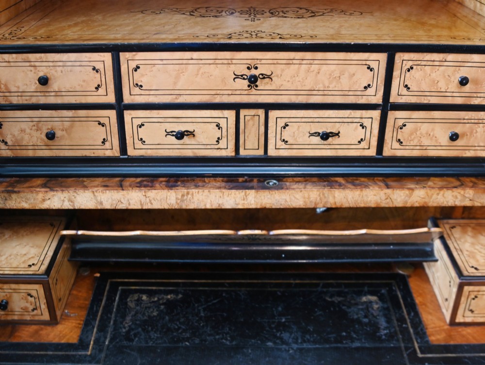 A tall 19th-century French Louis Philippe secretaire desk featuring figured birds-eye maple veneer, carved wooden handles, upper cabinet doors, and finials on top. View XI