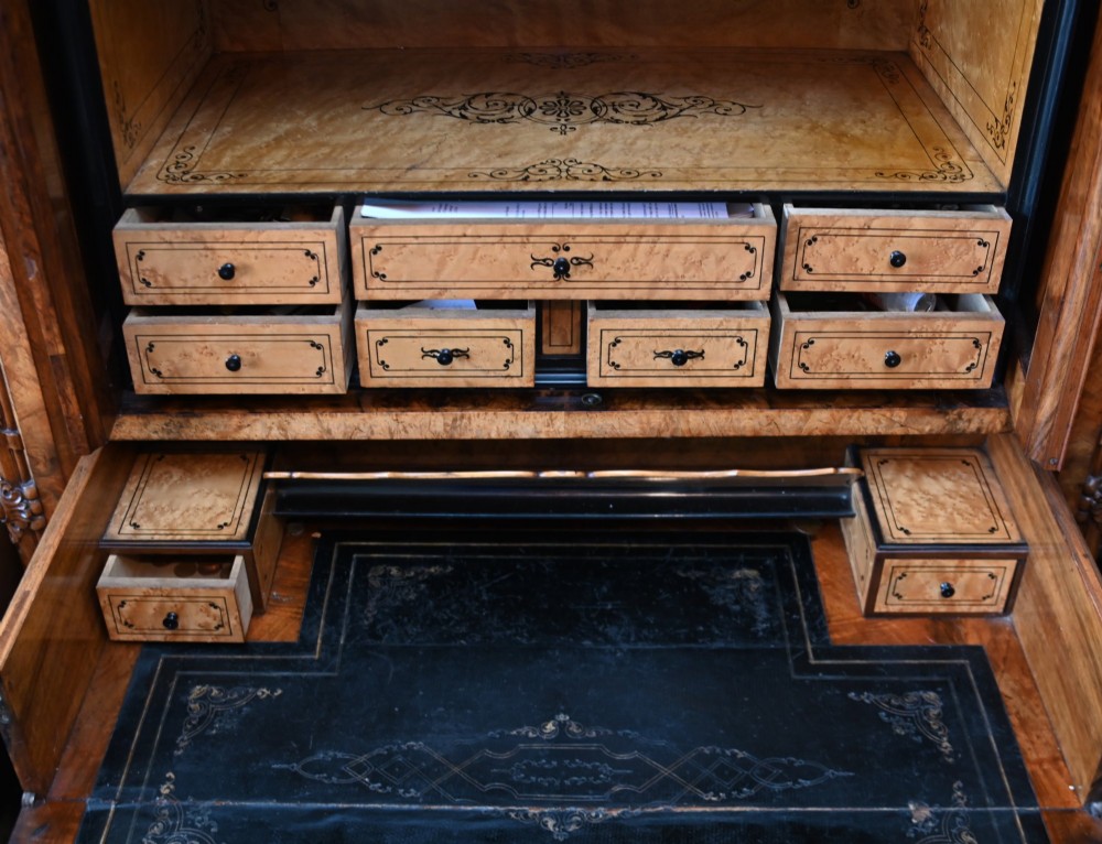 A tall 19th-century French Louis Philippe secretaire desk featuring figured birds-eye maple veneer, carved wooden handles, upper cabinet doors, and finials on top. View XIII