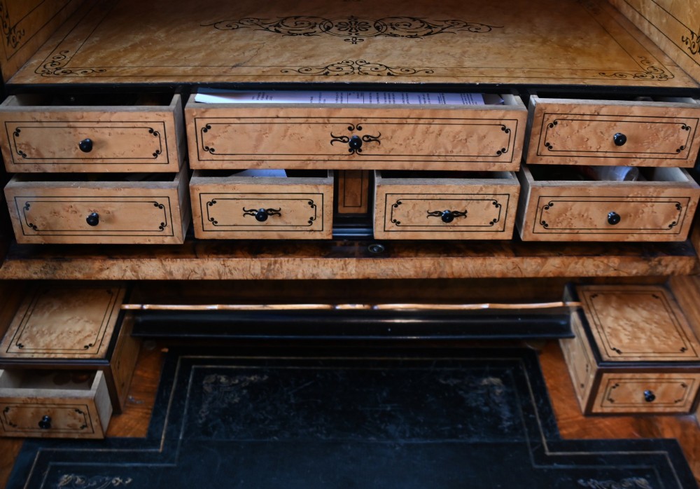 A tall 19th-century French Louis Philippe secretaire desk featuring figured birds-eye maple veneer, carved wooden handles, upper cabinet doors, and finials on top. View XIV