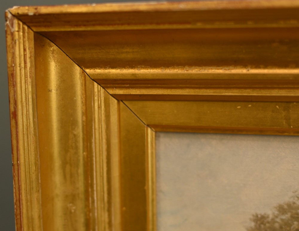 A 19th-century Victorian oil painting depicting a river landscape with trees and a wooden bridge, housed in a moulded gold gilt frame. View IX