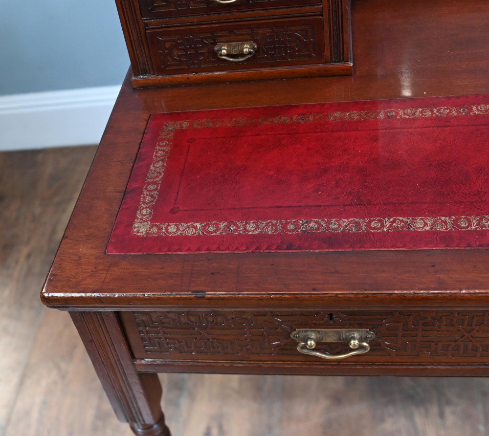 A mahogany ladies writing desk featuring a red leather inset writing surface, a central mirror superstructure flanked by drawers, and turned legs on castors. View IV