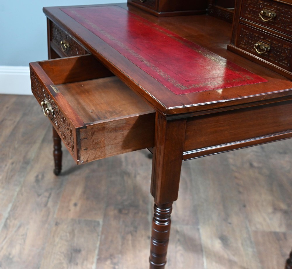 A mahogany ladies writing desk featuring a red leather inset writing surface, a central mirror superstructure flanked by drawers, and turned legs on castors. View VIII