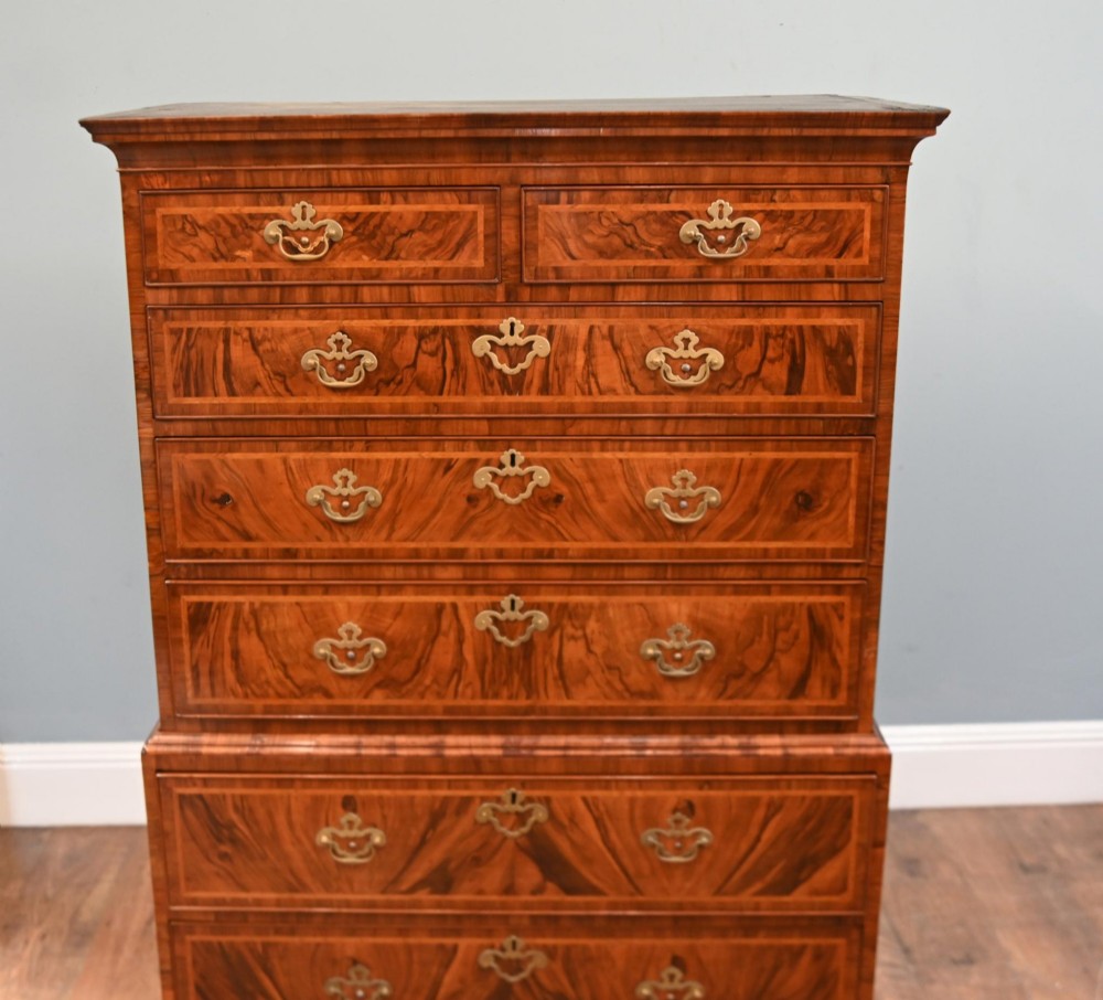 An 18th-century George II walnut chest on chest featuring figured veneered drawer fronts, brass swan-neck handles, and bracket feet. View II