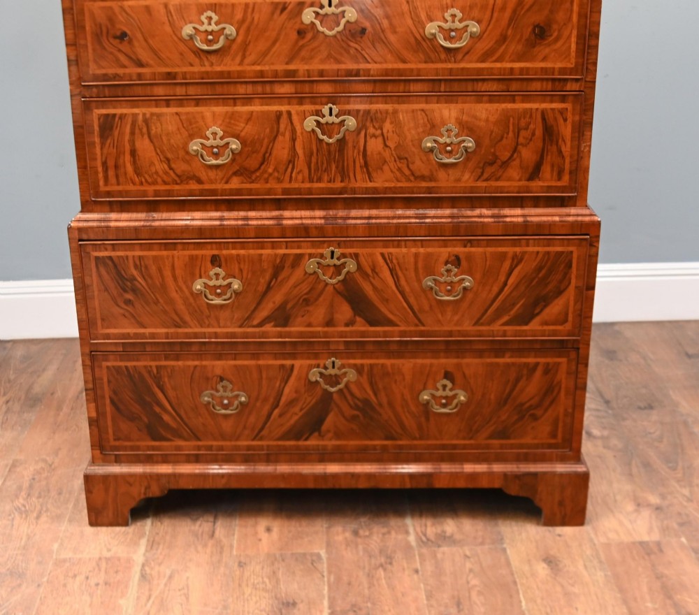 An 18th-century George II walnut chest on chest featuring figured veneered drawer fronts, brass swan-neck handles, and bracket feet. View III