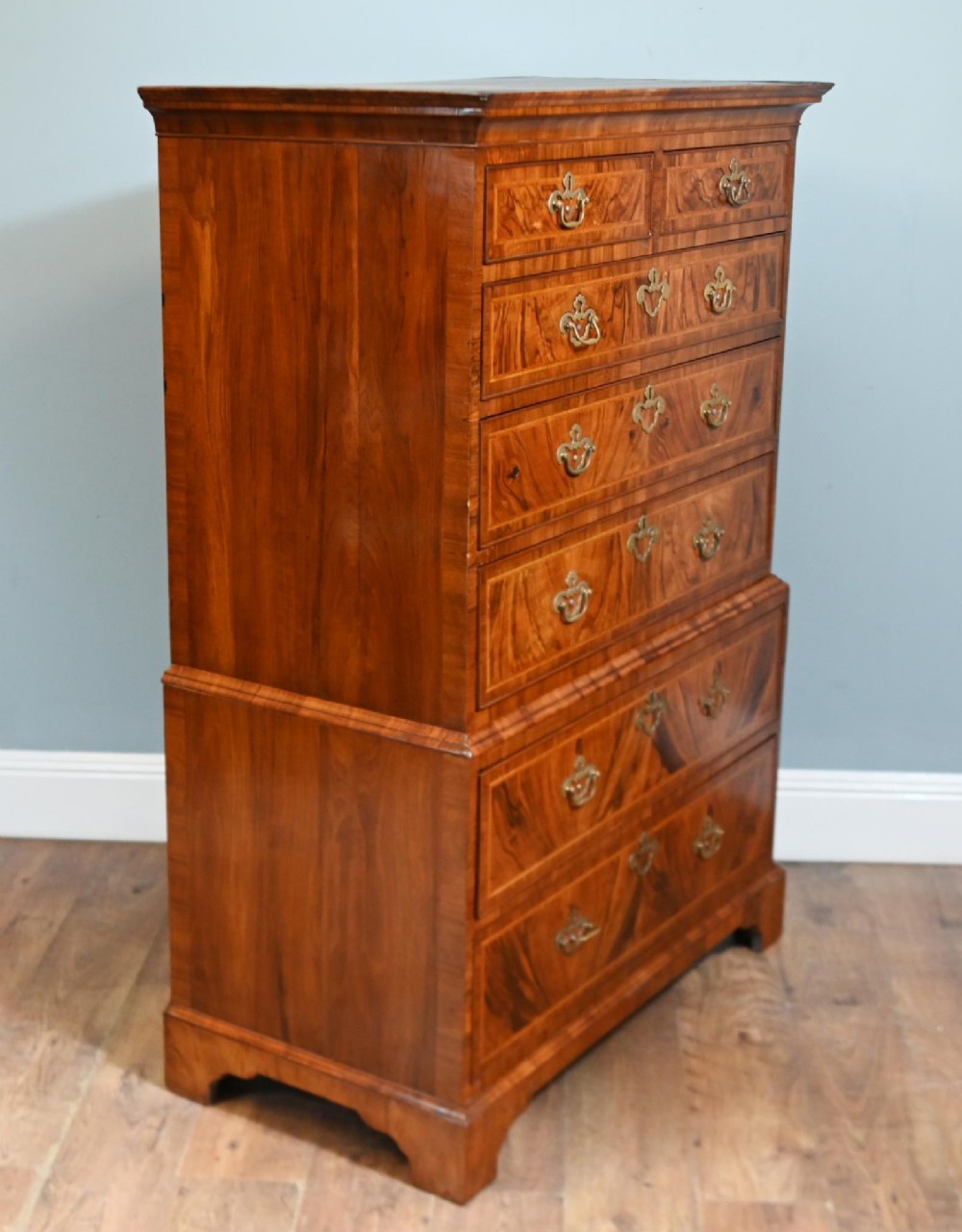 An 18th-century George II walnut chest on chest featuring figured veneered drawer fronts, brass swan-neck handles, and bracket feet. View VIII