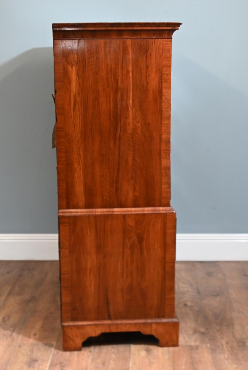 An 18th-century George II walnut chest on chest featuring figured veneered drawer fronts, brass swan-neck handles, and bracket feet. View IX