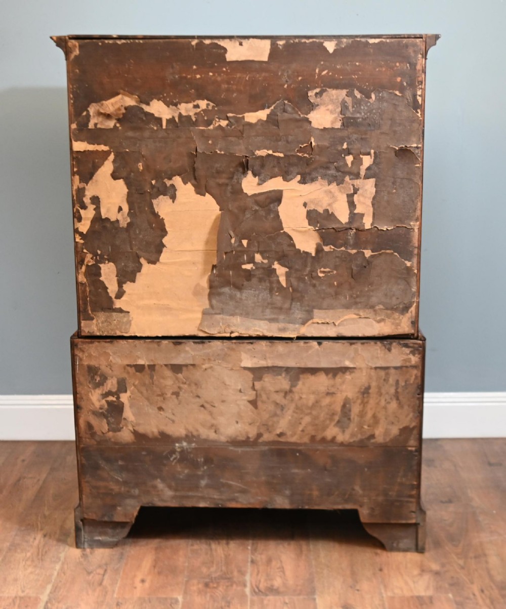 An 18th-century George II walnut chest on chest featuring figured veneered drawer fronts, brass swan-neck handles, and bracket feet. View X