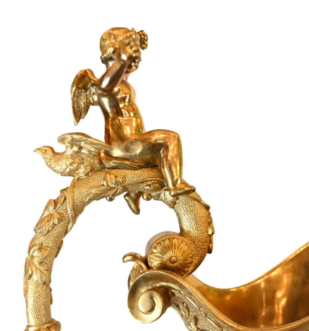 A pair of 19th-century French gilt bronze ewers featuring detailed Bacchus relief scenes, leaf motifs, and cherub-topped handles. View VIII