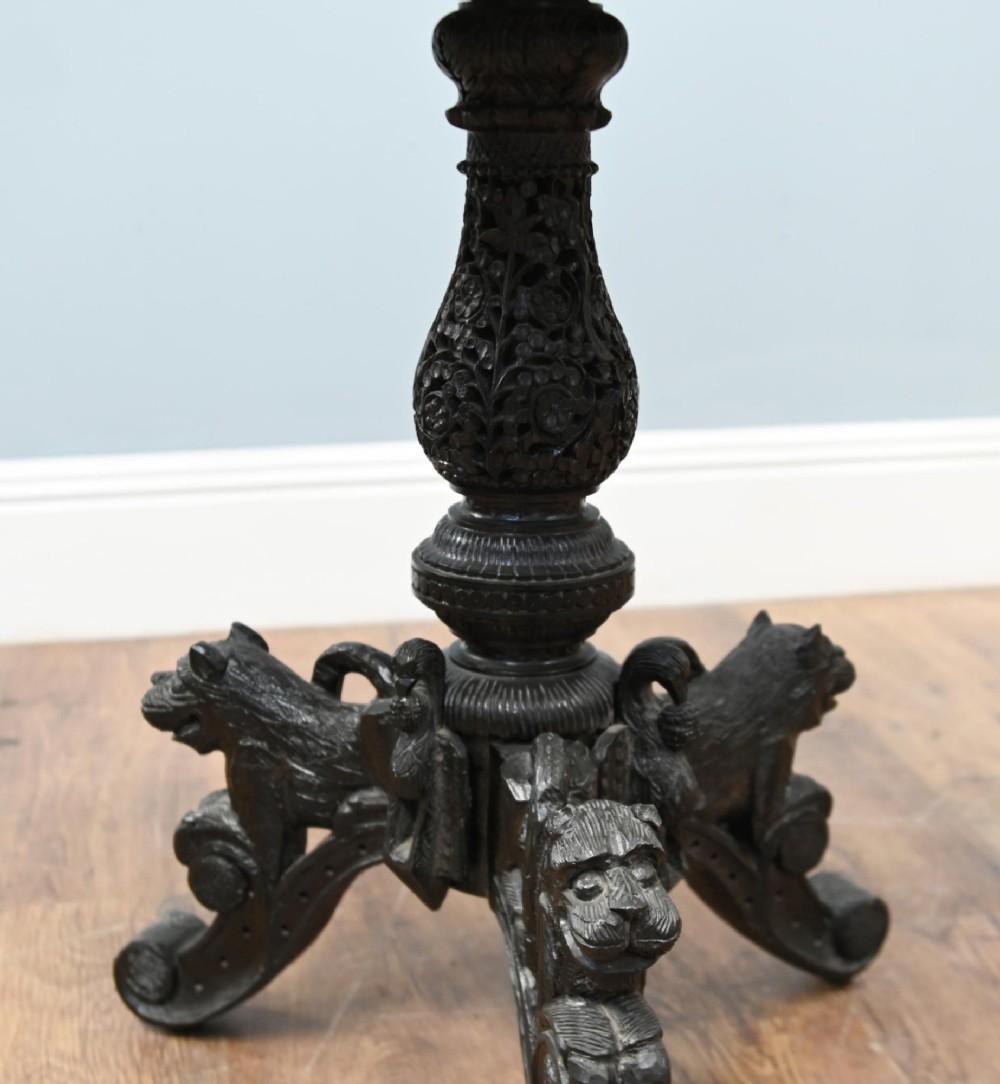 An antique octagonal dark hardwood side table featuring intricate pierced floral carvings around the apron and a central turned pedestal supported by three mythical carved beast legs. View VIII