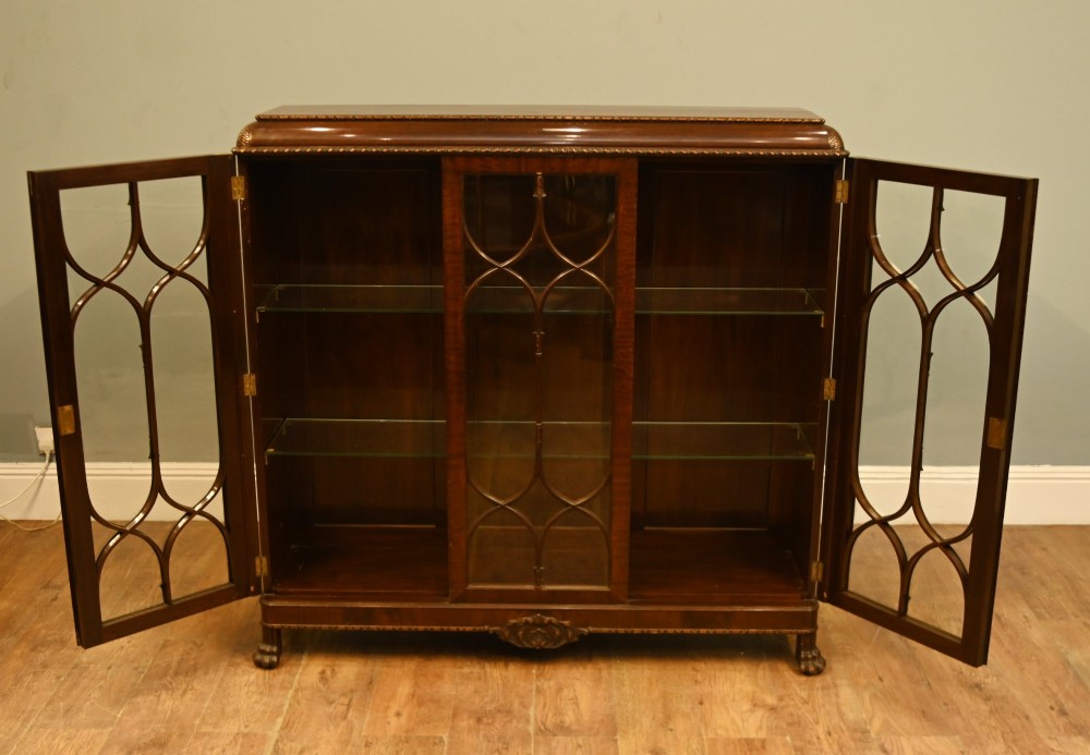 A Chippendale Revival mahogany display cabinet featuring three astragal glazed doors and carved ball and claw feet. View III