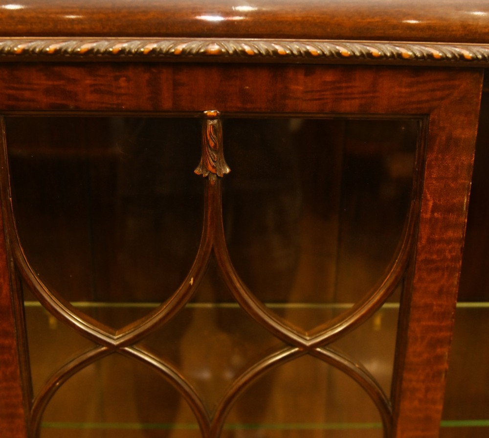 A Chippendale Revival mahogany display cabinet featuring three astragal glazed doors and carved ball and claw feet. View V