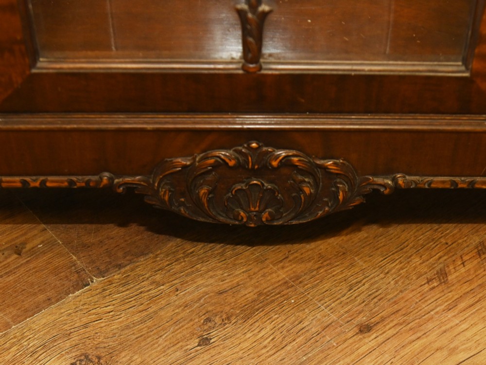 A Chippendale Revival mahogany display cabinet featuring three astragal glazed doors and carved ball and claw feet. View VIII