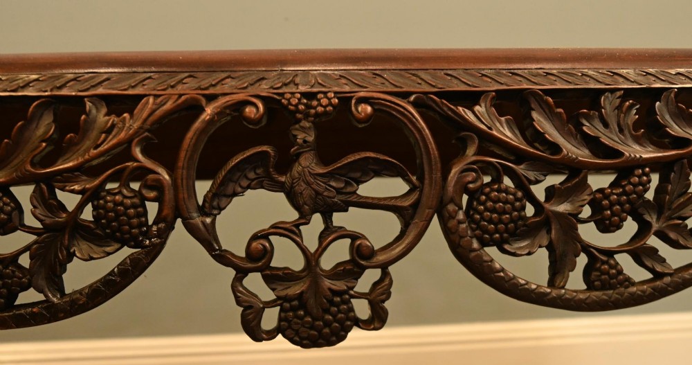 A dark hardwood Qing Dynasty console table featuring intricate carved openwork aprons and scrolled cabriole legs. View III