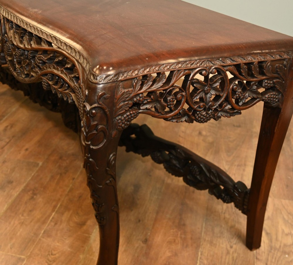 A dark hardwood Qing Dynasty console table featuring intricate carved openwork aprons and scrolled cabriole legs. View VI