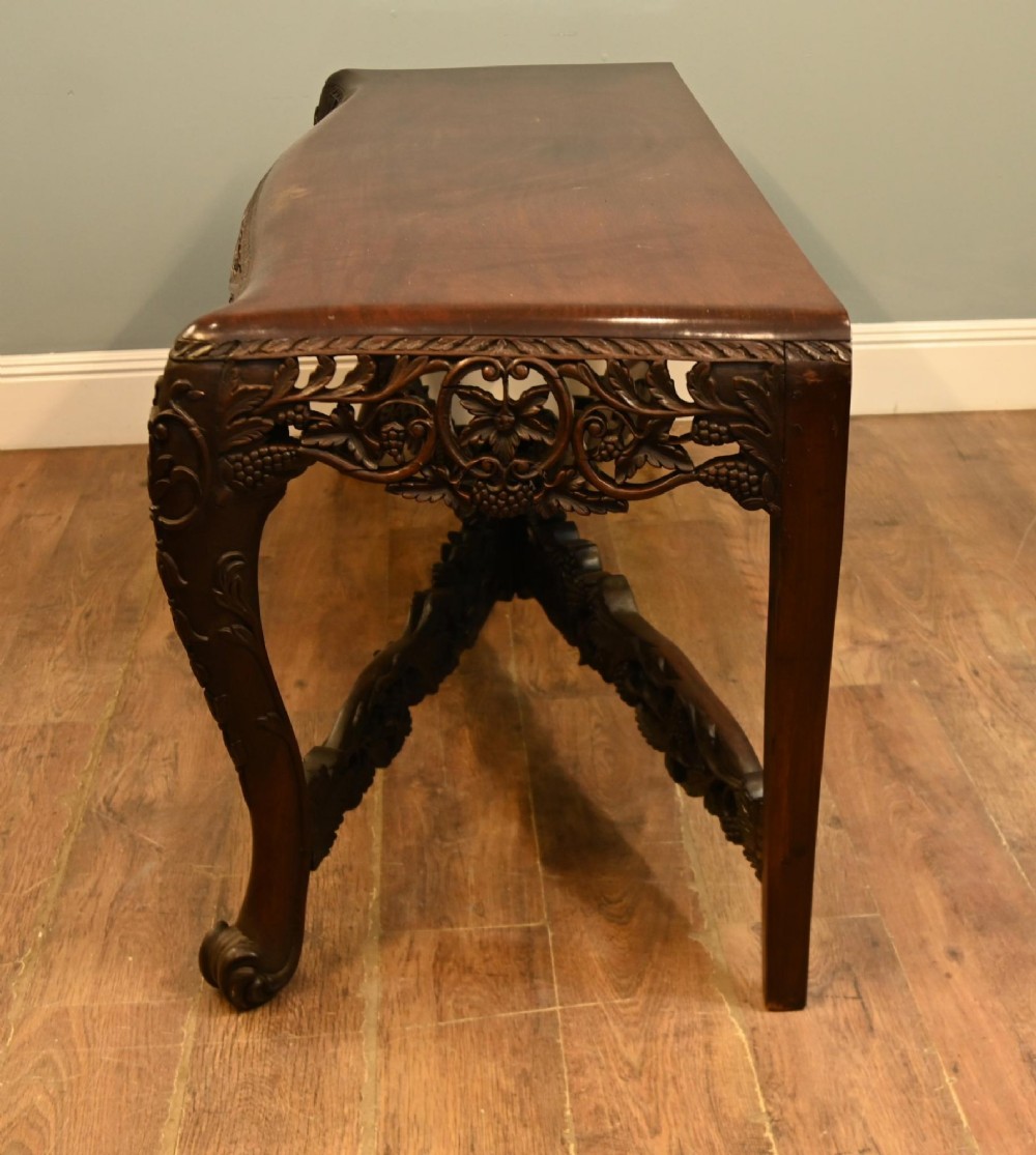 A dark hardwood Qing Dynasty console table featuring intricate carved openwork aprons and scrolled cabriole legs. View VII