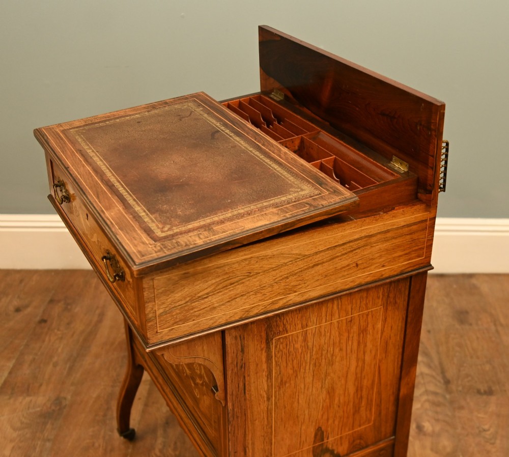 An Edwardian mahogany Davenport desk with urn marquetry inlays, a leather writing slope, brass gallery rim, and legs on castors. View V