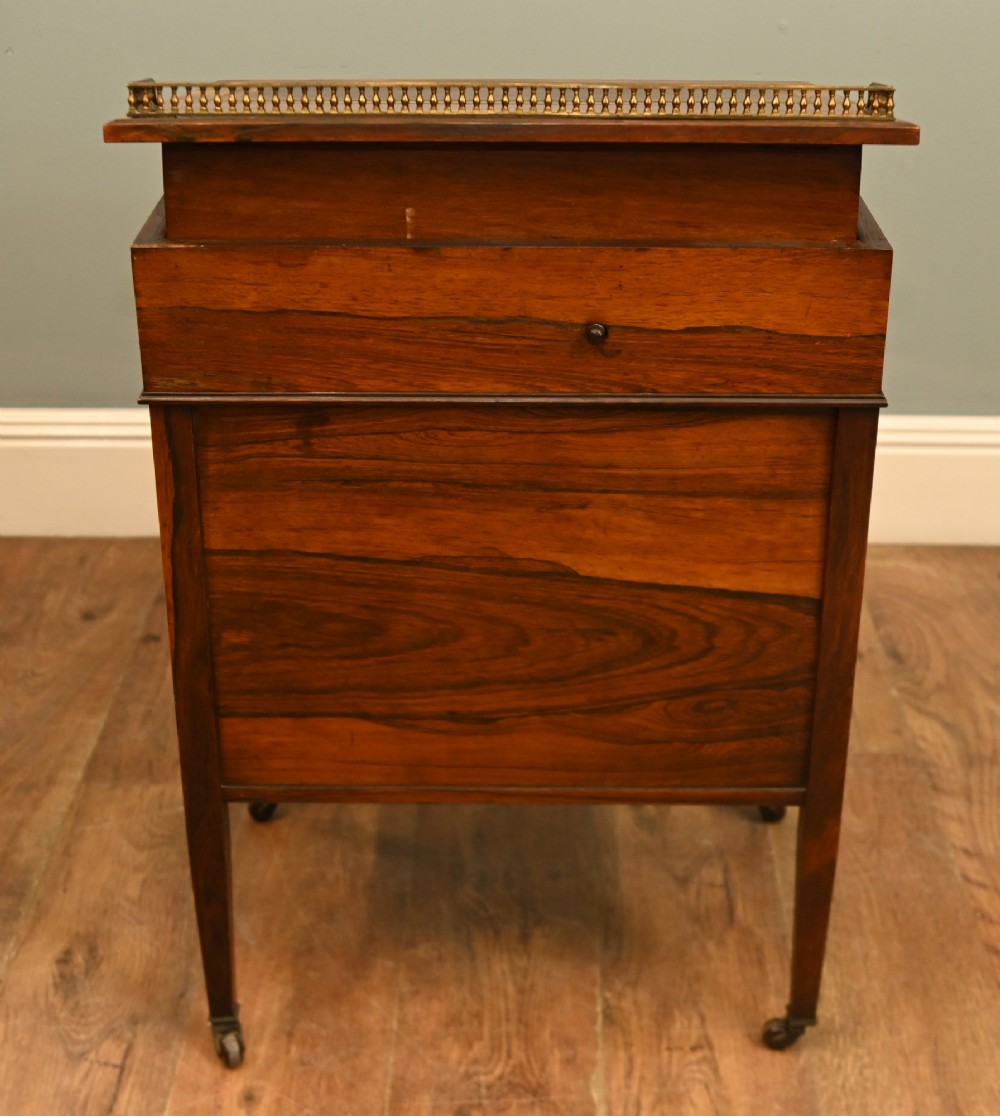 An Edwardian mahogany Davenport desk with urn marquetry inlays, a leather writing slope, brass gallery rim, and legs on castors. View VIII