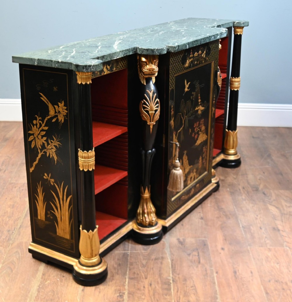 A Regency Revival side cabinet featuring a green marble top, a central black lacquer door decorated with gilded Chinoiserie artwork, and flanking open shelves with red interiors. View IV
