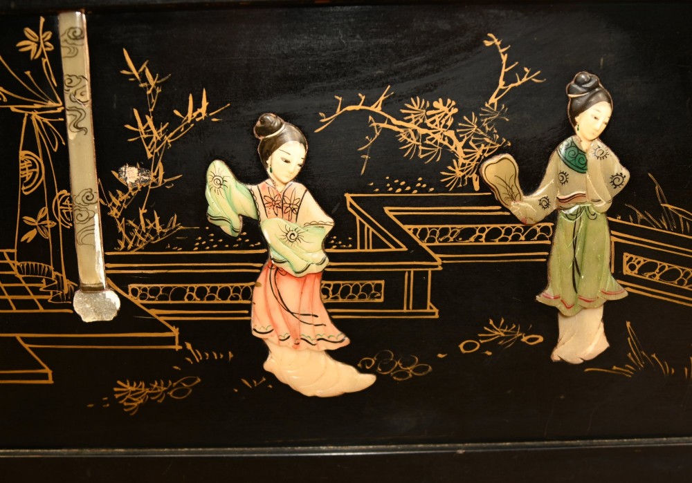 A black lacquered rectangular wooden chest embellished with raised soapstone figures and landscape scenes, fitted with an etched brass lock plate. View II