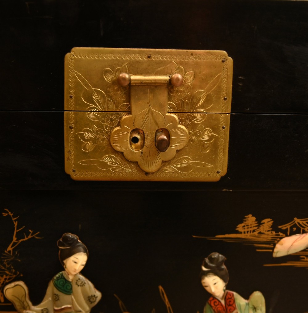 A black lacquered rectangular wooden chest embellished with raised soapstone figures and landscape scenes, fitted with an etched brass lock plate. View IV