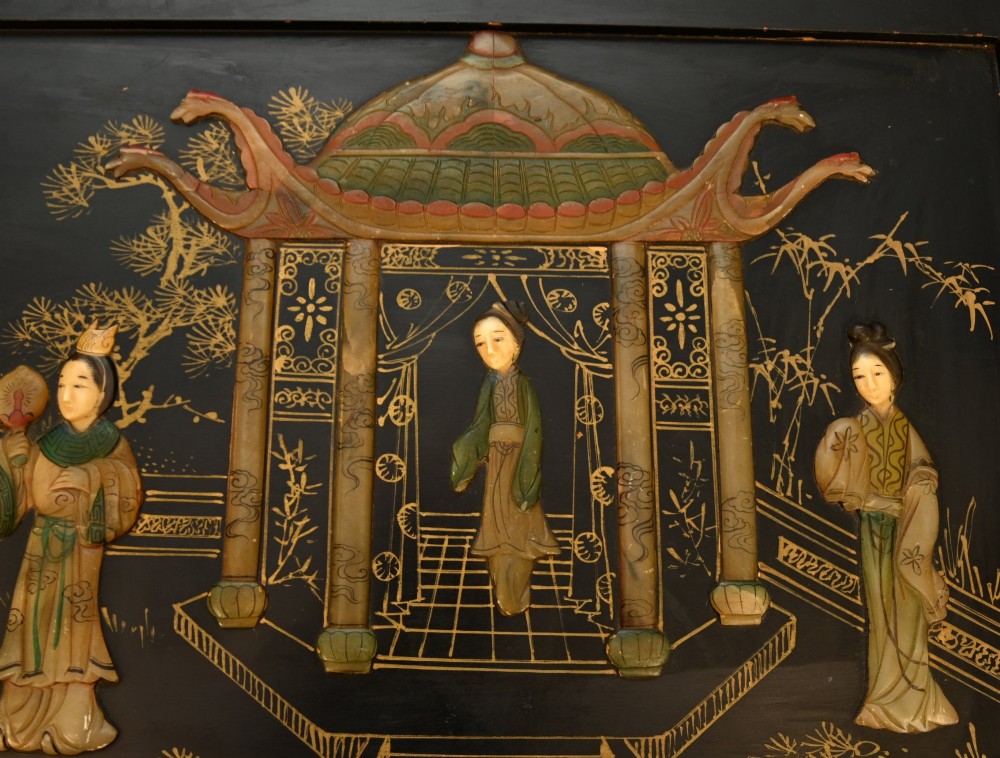 A black lacquered rectangular wooden chest embellished with raised soapstone figures and landscape scenes, fitted with an etched brass lock plate. View VI