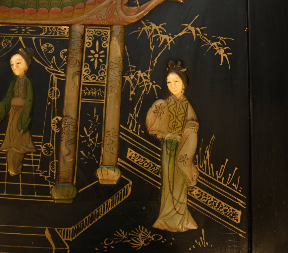 A black lacquered rectangular wooden chest embellished with raised soapstone figures and landscape scenes, fitted with an etched brass lock plate. View VII