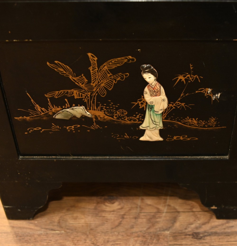 A black lacquered rectangular wooden chest embellished with raised soapstone figures and landscape scenes, fitted with an etched brass lock plate. View X