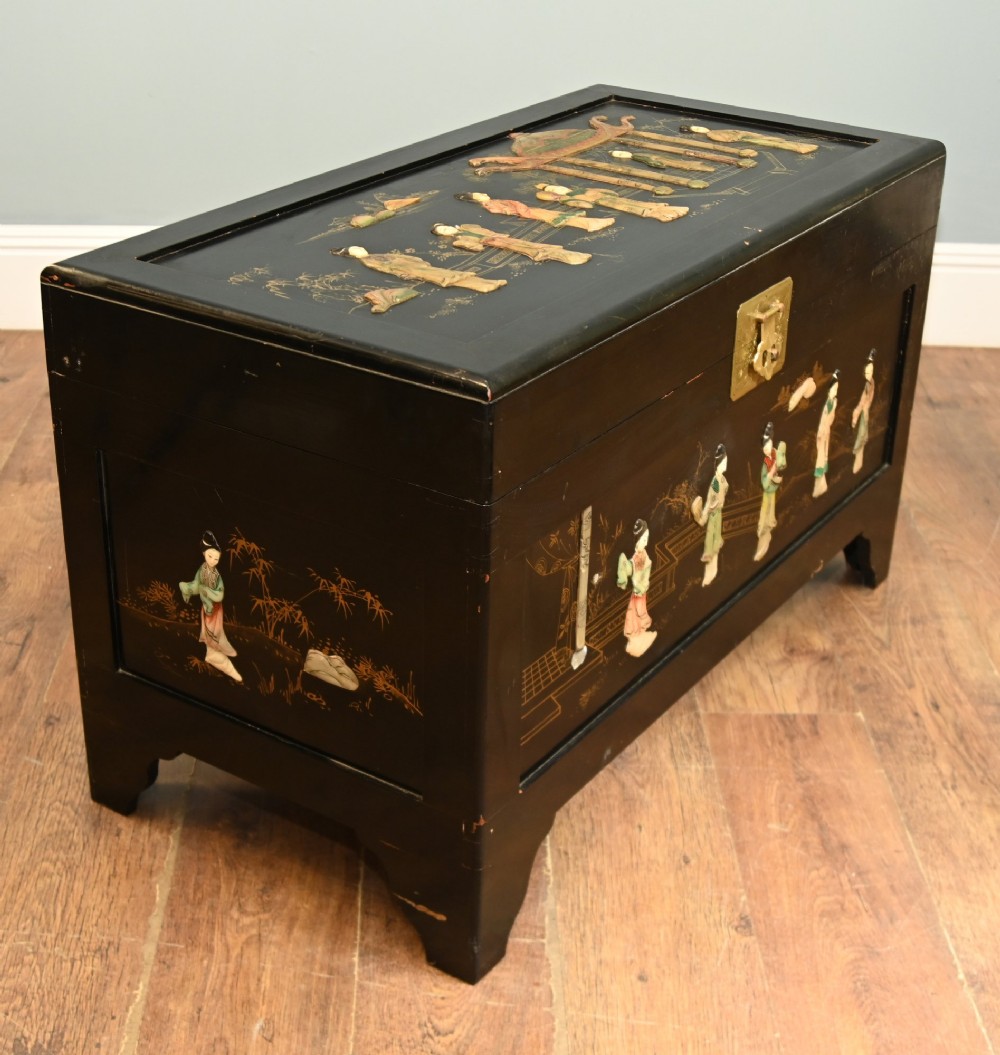 A black lacquered rectangular wooden chest embellished with raised soapstone figures and landscape scenes, fitted with an etched brass lock plate. View XI