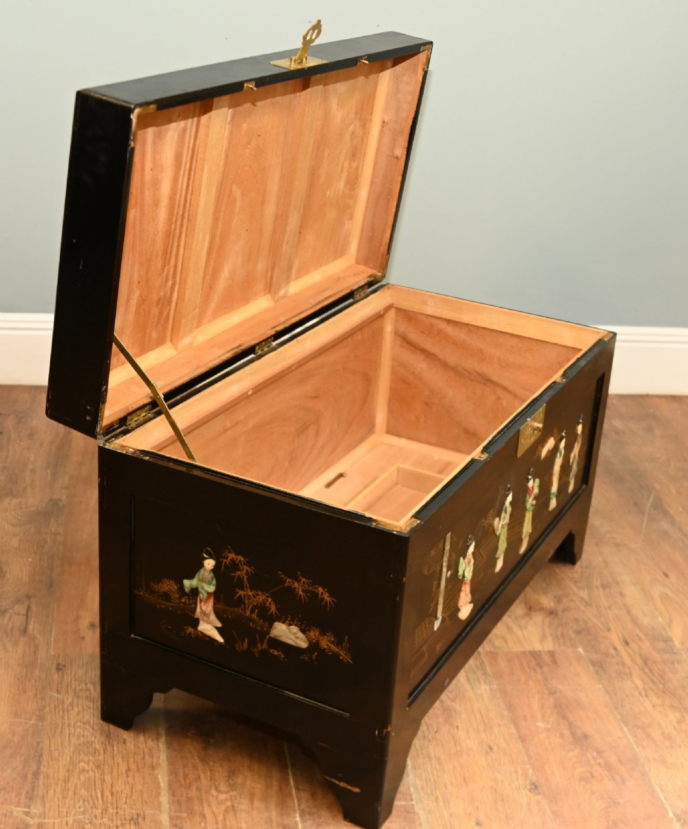 A black lacquered rectangular wooden chest embellished with raised soapstone figures and landscape scenes, fitted with an etched brass lock plate. View XIII