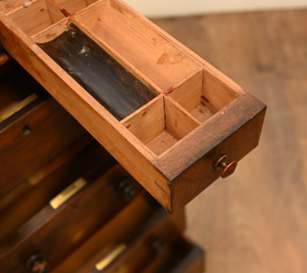 A Victorian mahogany Davenport desk featuring a sloped leather writing top, carved cresting rail, serpentine front supports, and side drawers. View IV