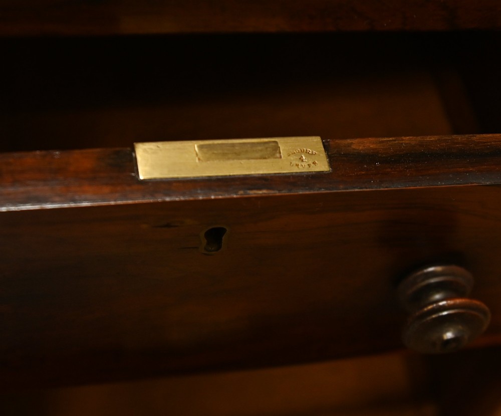 A Victorian mahogany Davenport desk featuring a sloped leather writing top, carved cresting rail, serpentine front supports, and side drawers. View V