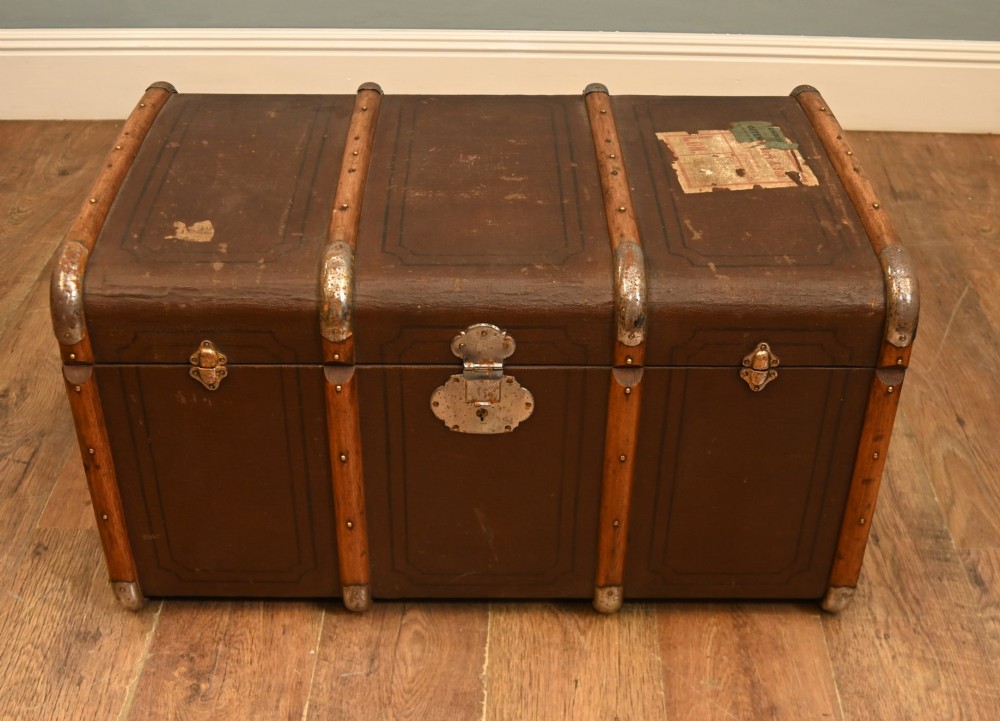 A dark brown 1920s antique steamer trunk with wooden slats, corner brackets, and a central metal latch. View II
