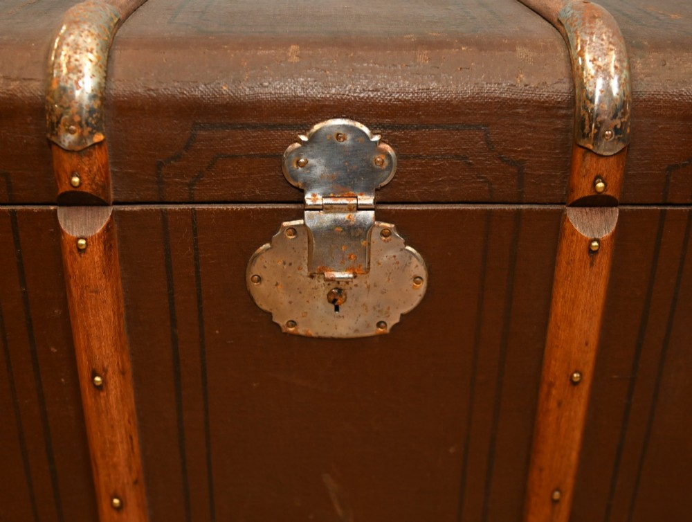 A dark brown 1920s antique steamer trunk with wooden slats, corner brackets, and a central metal latch. View III
