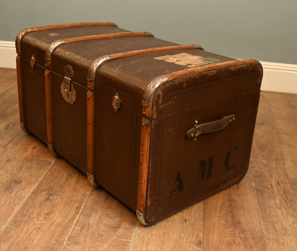 A dark brown 1920s antique steamer trunk with wooden slats, corner brackets, and a central metal latch. View IV