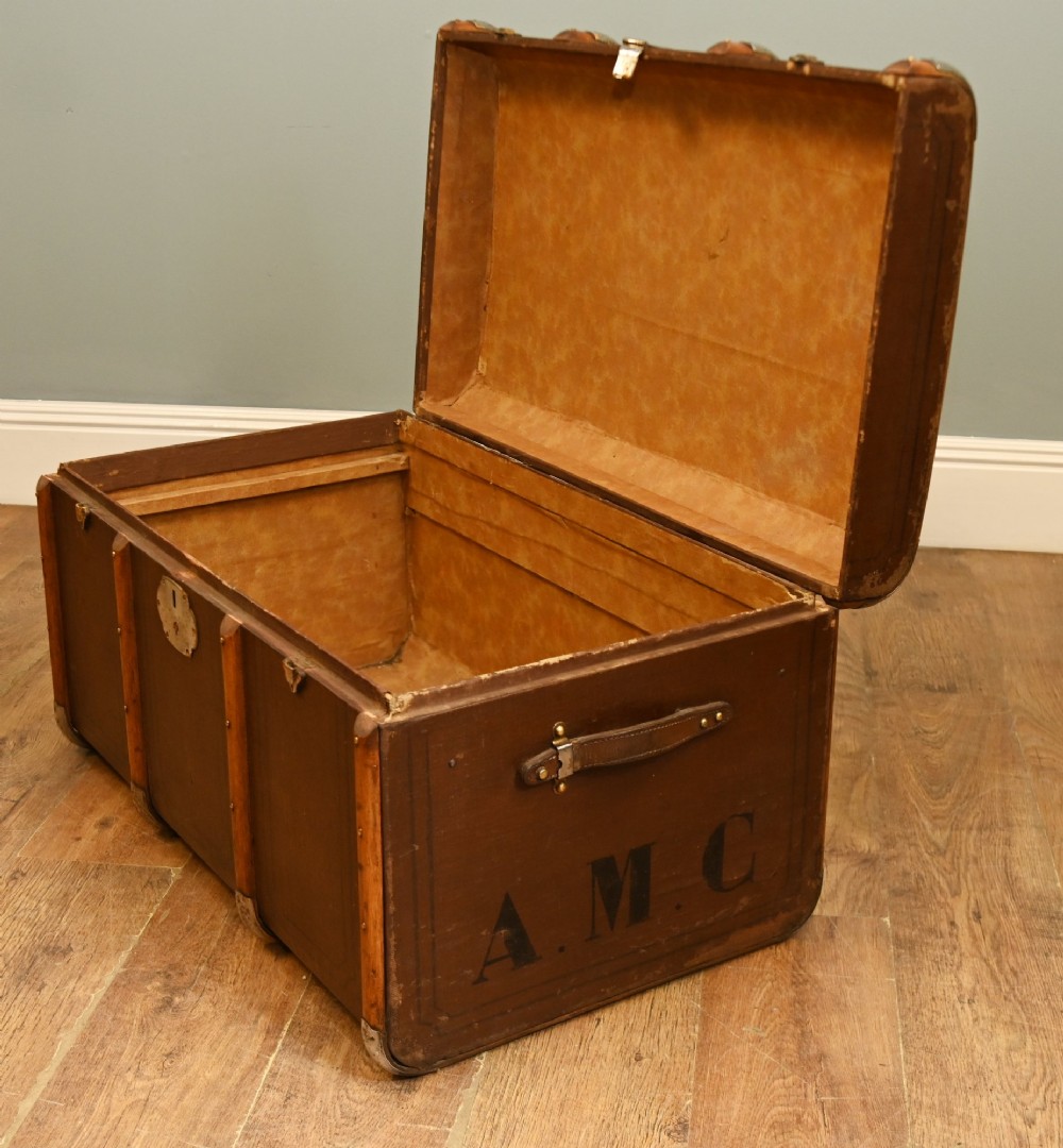 A dark brown 1920s antique steamer trunk with wooden slats, corner brackets, and a central metal latch. View V
